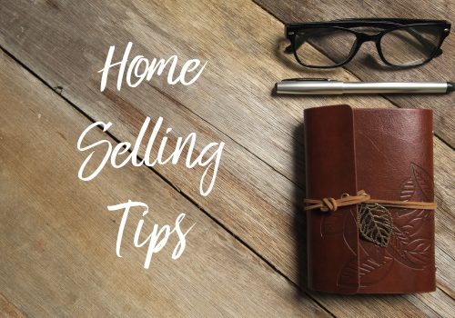 Top view of pen,glasses and notebook on wooden background written with Home Selling Tips.